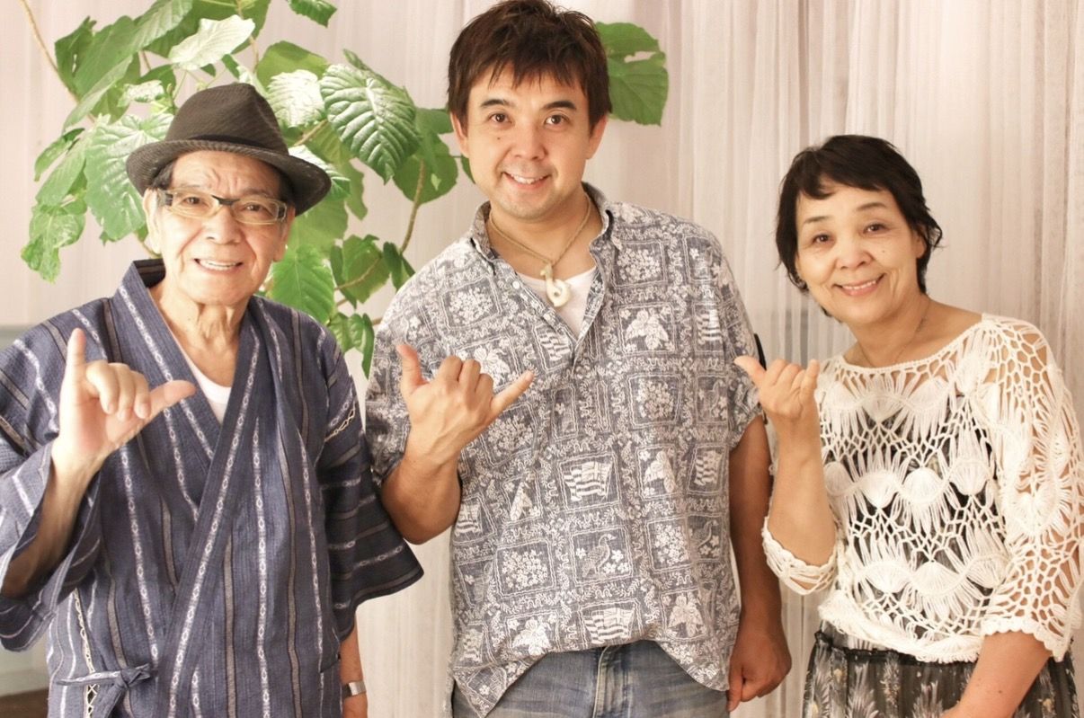 両親と並んでシャカサインをする岩上巧